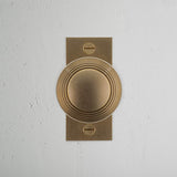 Poplar Short Plate Sprung Door Knob Antique Brass Finish on White Background right Facing Front View