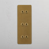 Six Lever Triple Vertical Toggle Switch in Antique Brass on White Background