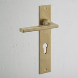 Clayton Long Plate Sprung Door Handle & Euro Lock Antique Brass Finish on White Background at an Angle