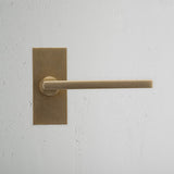 Clayton Short Plate Sprung Door Handle Antique Brass Finish on White Background Front Facing
