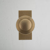 Poplar Short Plate Sprung Door Knob Antique Brass Finish on White Background Front Facing